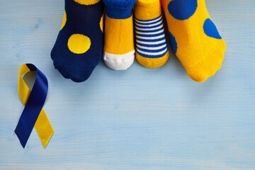 World Down syndrome day background. Down syndrome awareness concept. Socks and ribbon on blue...