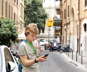 Teenage boy typing text message,Using smart phone,young man on a city street