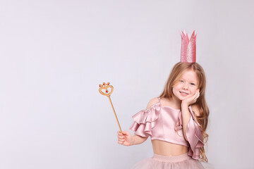 Cute girl in fairy dress with pink crown and magic wand on light grey background, space for text. Little princess © New Africa
