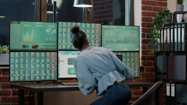 Female analyst looking at exchange market statistics on laptop and multi monitos, working on investment fund share growth. Financial sales with forex stock trade on charts and graphs.