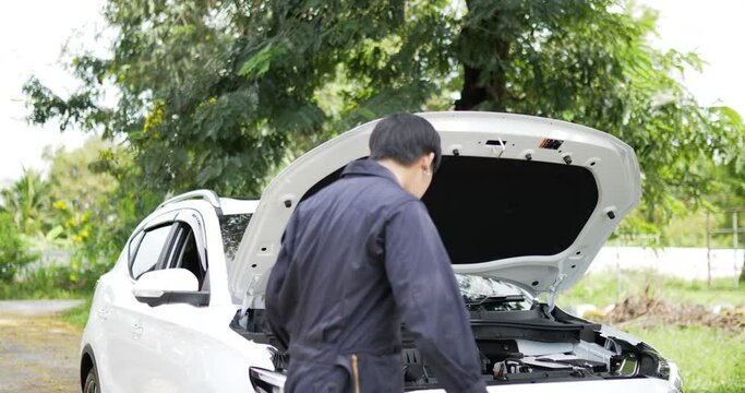 Asian automobile mechanic inspection shine a torch car engine checking bug in engine. Service maintenance insurance with car engine. Car service concept.