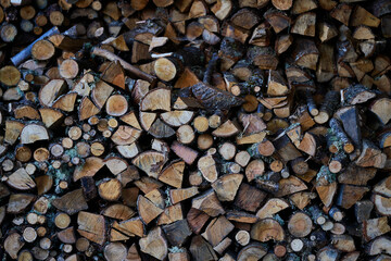 Stacked wood forming a wall in which the shapes of the logs can be seen