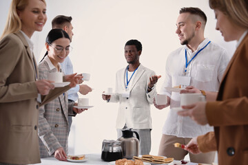 Group of people chatting during coffee break indoors