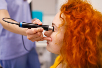 A doctor checking the eye pressure of her female patient