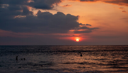 sunset on the ocean with surfers in sri lanka