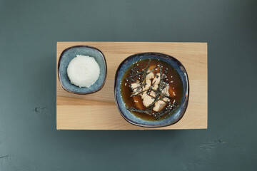 Japanese miso soup and rice on a red bowl and spoon on the table.