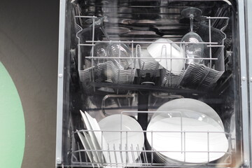 The dishwasher is full of clean dishes, kitchen appliances. High quality photo