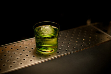 angle view of one full glass of cocktail on the bar counter.