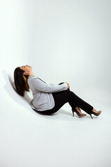 Fototapeta premium Full length portrait of smiling attractive businesswoman in suit posing while standing with arms crossed and looking at camera isolated over white background