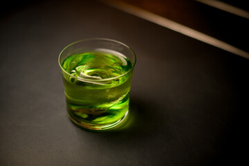 Close-up view of one full glass of cold cocktail on black table