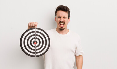 young handsome man shouting aggressively, looking very angry. dart target concept