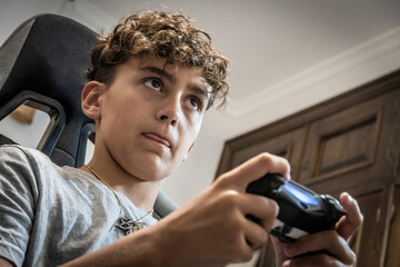 Concentrated face of a teenager playing with the console