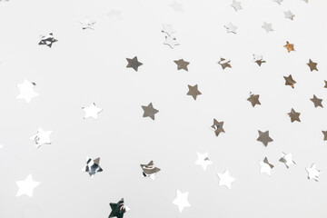 star silver confetti on white background flat lay text place .