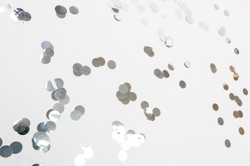 round silver confetti on white background flat lay text place .