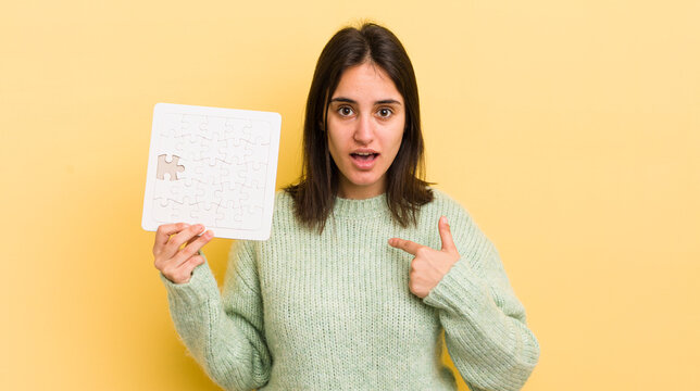 Young Hispanic Woman Feeling Happy And Pointing To Self With An Excited. Puzzle Concept