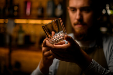 Selective focus of clean transparent empty old fashioned glass in male hands