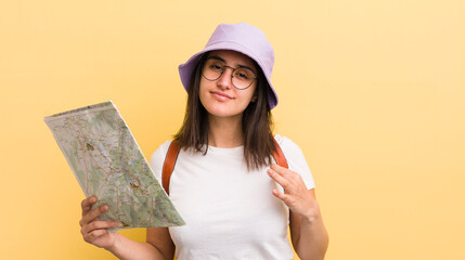 young hispanic woman looking arrogant, successful, positive and proud. tourist and map concept