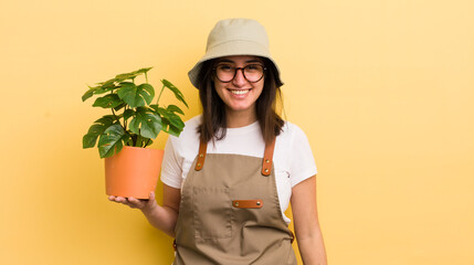young hispanic woman looking happy and pleasantly surprised. gardener and plant concept