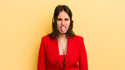 young hispanic woman feeling disgusted and irritated and tongue out. telemarketer concept