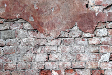 old brick wall with cracked plaster