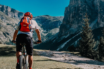 Man cycling electric , rides mountain trail above Garda. Man riding on bike in  mountain landscape. Cycling e-mtb enduro trail track. Outdoor sport activity. - obrazy, fototapety, plakaty