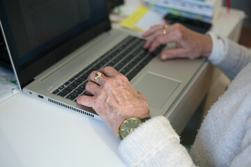 Elderly woman using the laptop - closeup on the hand - obrazy, fototapety, plakaty