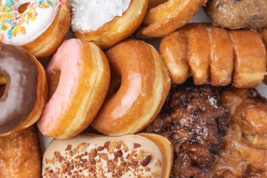 Overhead shot of a box of assorted donuts indoors under studio lighting.