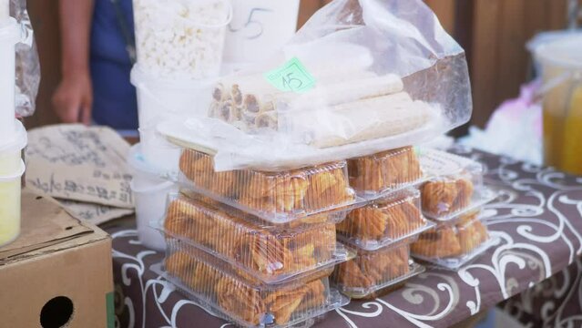 Sale Sweet Pastries in Plastic Boxes on Open Counters Summer in the Market. Sweet rolls, waffles are sold with price indications. Trading instant food on street stalls. Food truck. Local food.