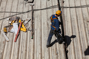 Ekibastuz, Pavlodar region, Kazakhstan - May 28, 2012: GRES-1 steam power station. Industrial climber builder on metal roof.