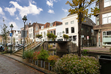 Fototapeta premium Small bridge over the canal with flower pots and canal houses in the center of the city of Gouda