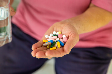 An old woman holds pills in her hands. Selective focus.