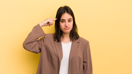 young hispanic woman feeling confused and puzzled, showing you are insane, crazy or out of your mind