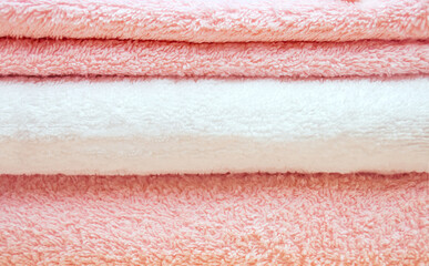 The texture of white and pink terry towels stacked.