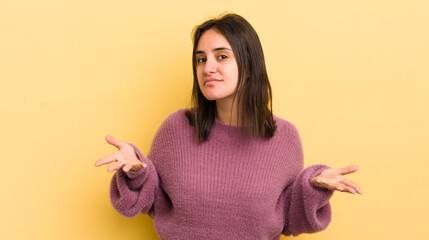 young hispanic woman feeling clueless and confused, having no idea, absolutely puzzled with a dumb...
