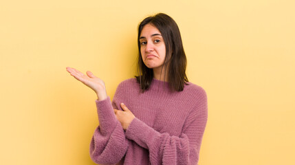 young hispanic woman feeling confused and clueless, wondering about a doubtful explanation or...