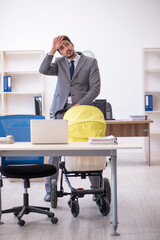 Young male employee looking after new born at workplace