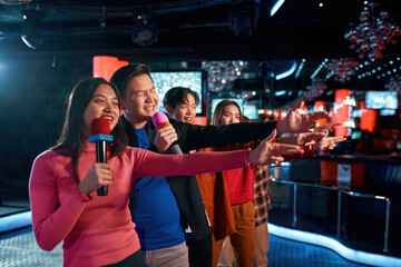 Clubbers rocking and chilling out in karaoke club on stage