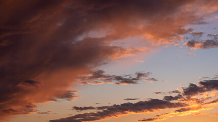 Dramatic sky at sunset shows clouds that transition from yellow hues to nearly black.