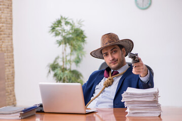 Young cowboy businessman working at workplace