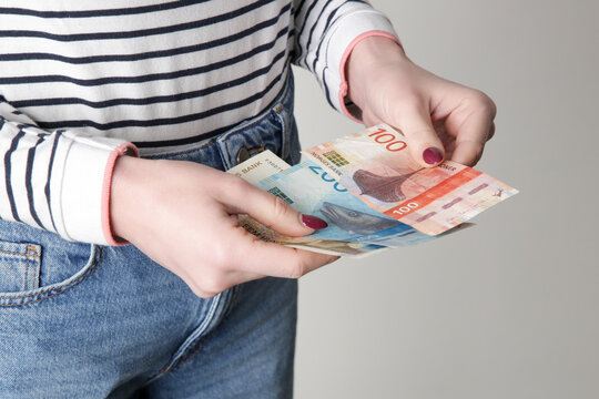 Woman holding Norwegian krone banknotes