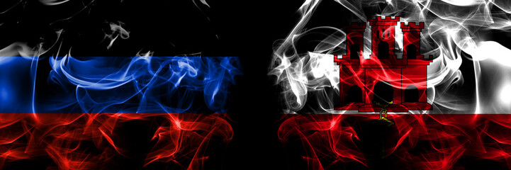 Obraz premium Donetsk People's Republic vs British, Britain, Gibraltar flag. Smoke flags placed side by side isolated on black background.
