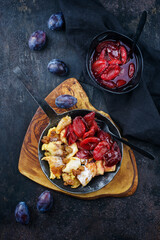 Traditioneller österreichisch Kaiserschmarren mit Zwetschgen und Rosinen serviert als Draufsicht in einer rustikalen Bratpfanne 