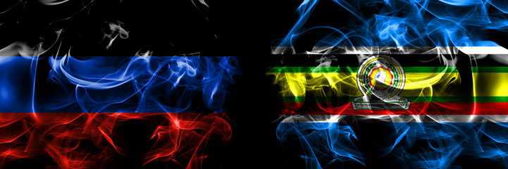 Donetsk People's Republic vs East African Community flag. Smoke flags placed side by side isolated on black background.