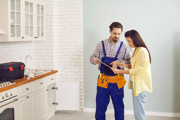 Male plumber or mechanic talk speak with female client at home. Man mechanic or repairman consult...