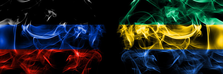 Donetsk People's Republic vs Gabon, Gabonese, Gabonian flag. Smoke flags placed side by side isolated on black background.