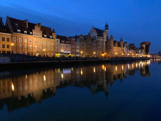Fototapeta na wymiar Dramatic picture of the historical buildings of Gdansk on the cold channel