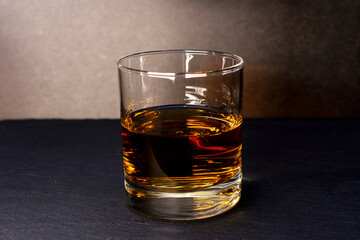 glass goblet with whiskey on a dark background