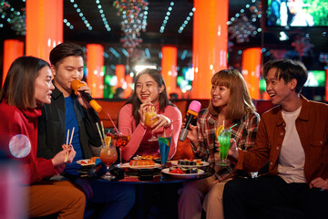 Karaoke together with friends and enjoying time in karaoke club,