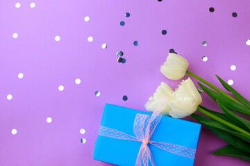 Gift box and spring flowers with confetti  on color background. Stylish soft image of spring flowers. Happy womens day. Happy Mothers day.Hello Spring- Image