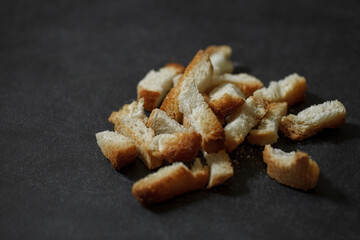 Dried bread rusks cooked, bunch, crumbs, close-up, on dark background, selective focus.